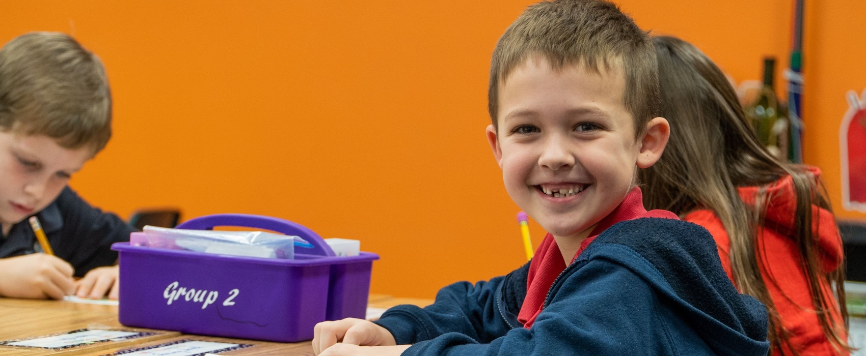 Student at desk smiling